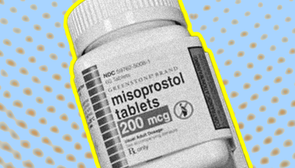 A container of misoprostol pills is centered on a background of yellow polka dots on top of a blue backing