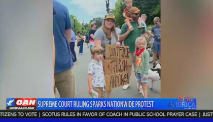 OANN attacs pregnant pro-choice protestor with three kids and husband. Their sign reads "don't force this on anyone!" Children look very calm. 