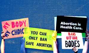 different protest signs read "My Body My Choice"; "You can only ban safe abortion"; "Abortion is healthcare"; "Bans off our bodies"