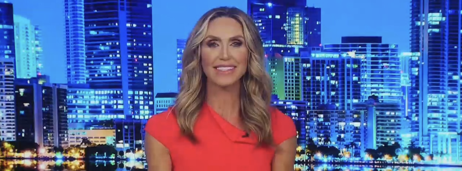Lara Trump dressed in red, on a blue-tinted Newsmax set